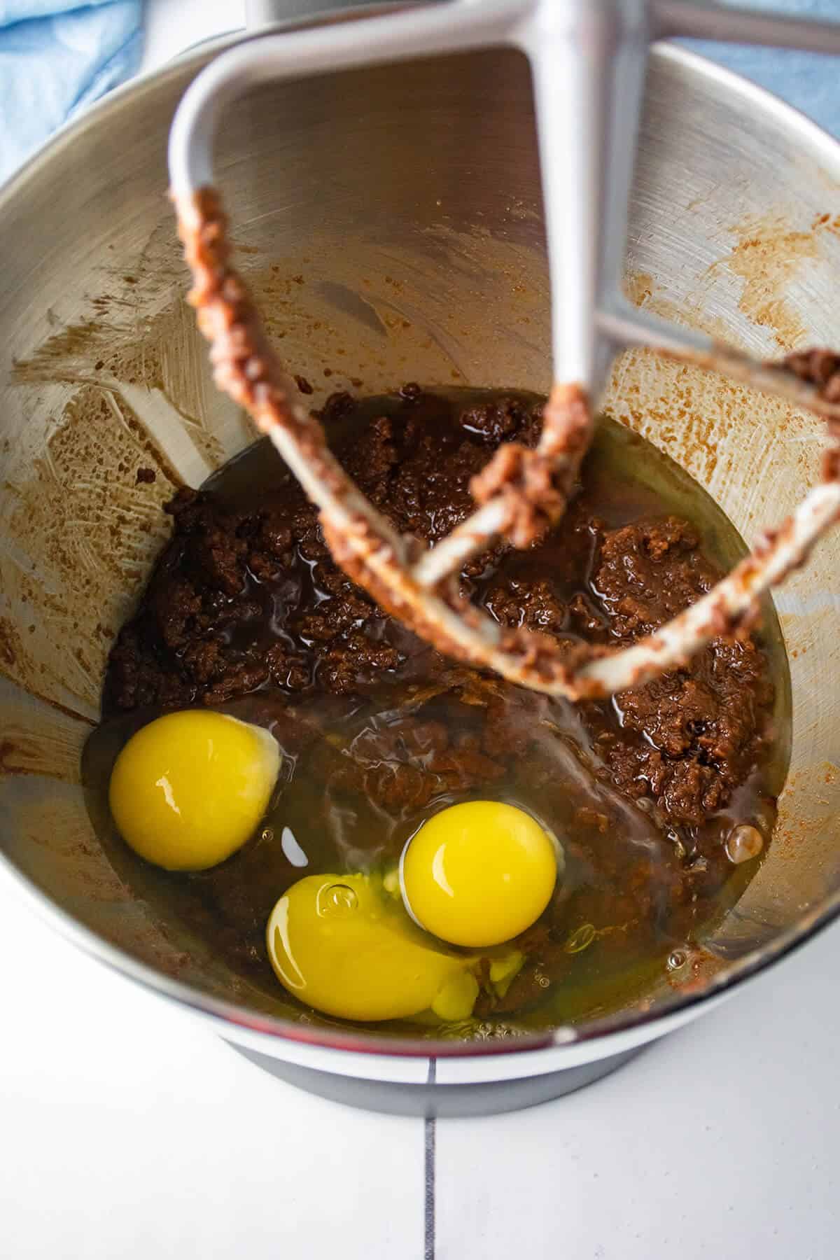 Eggs added to chocolate-sugar mixture in bowl.
