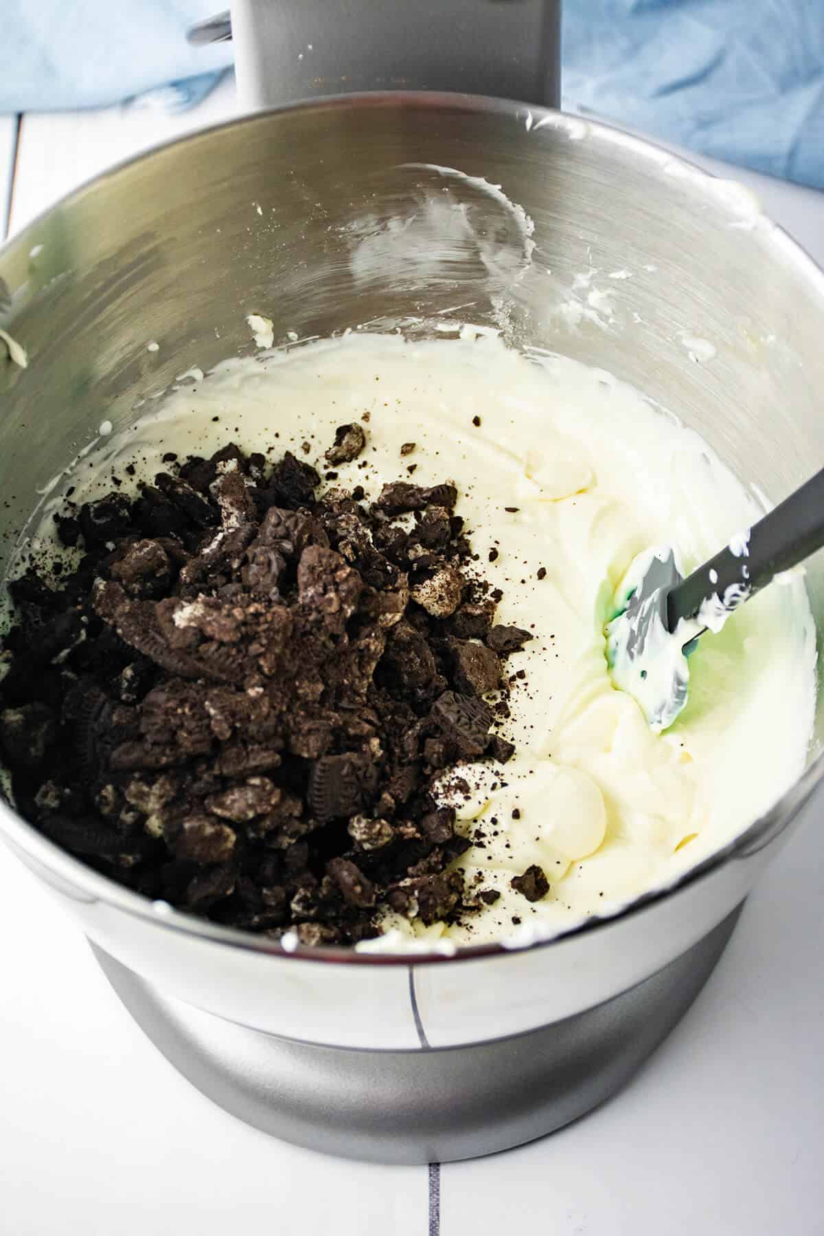 Adding crushed oreos to mixture.