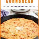 A skillet of cheesy green chile cornbread with a pat of butter melting on top.