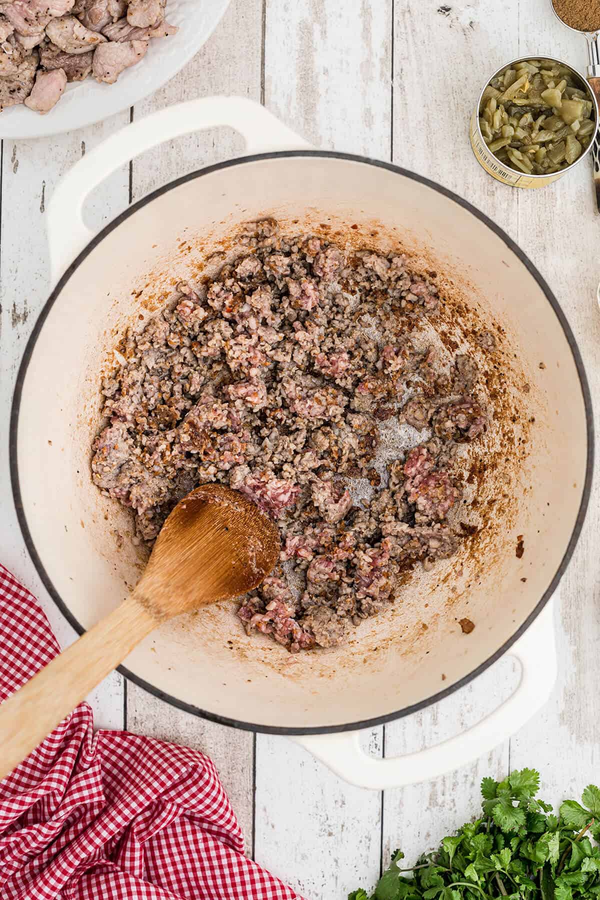Sausage cooking in a Dutch oven.