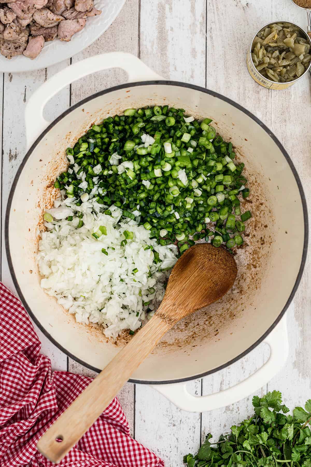 Onions and peppers cooking in a Dutch oven.