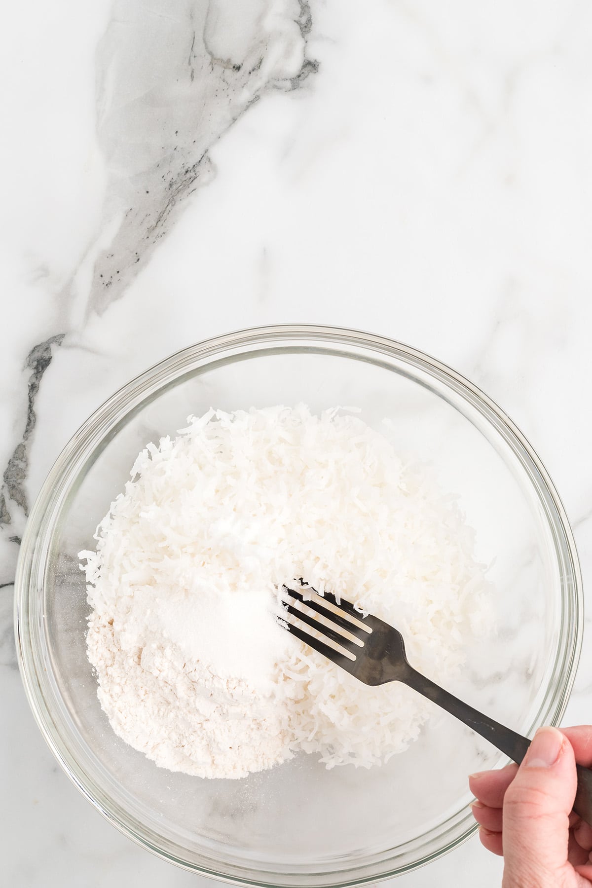 Coconut, sugar, and flour mixed in a bowl.