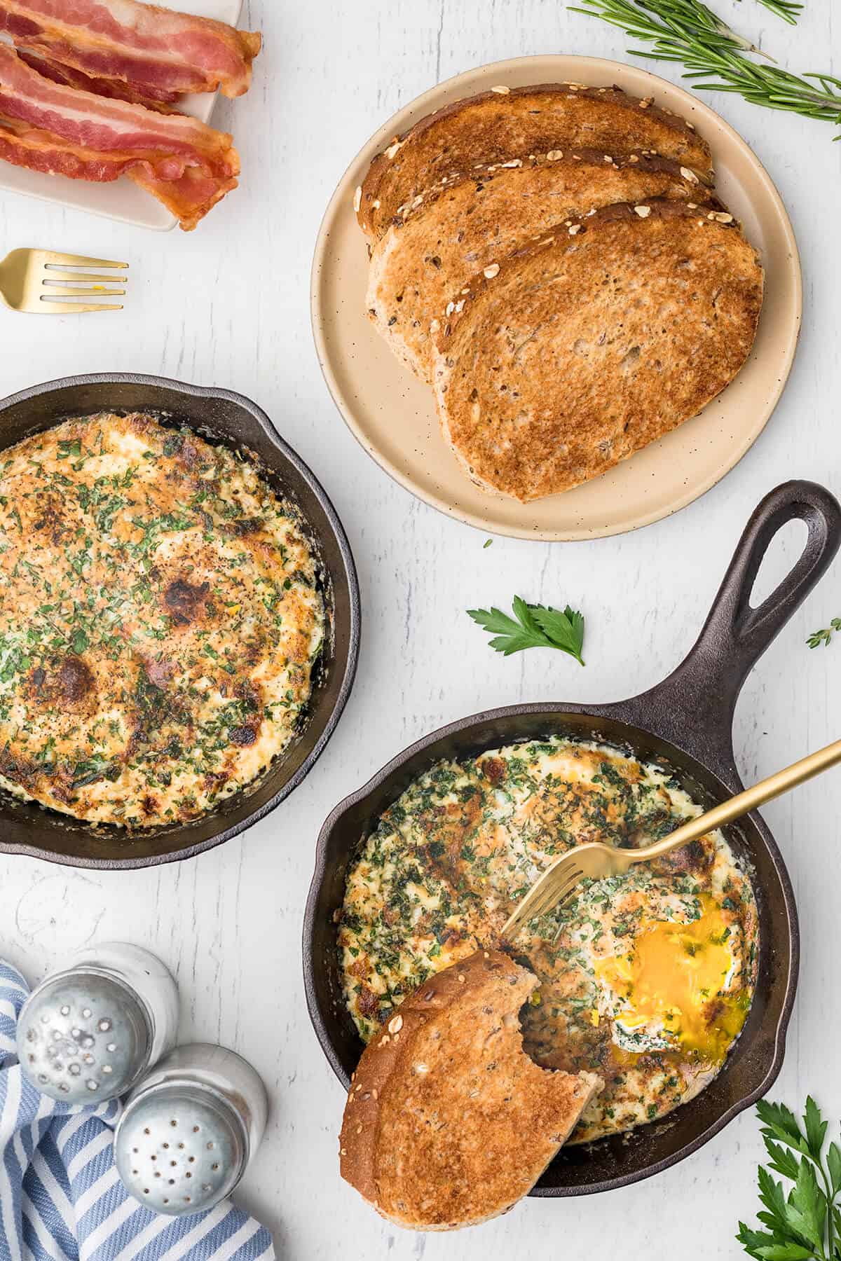 Finished baked eggs in small skillets with a fork and toast.