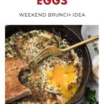 A skillet of herbed baked eggs with toast and a fork, garnished with herbs, on a white background.