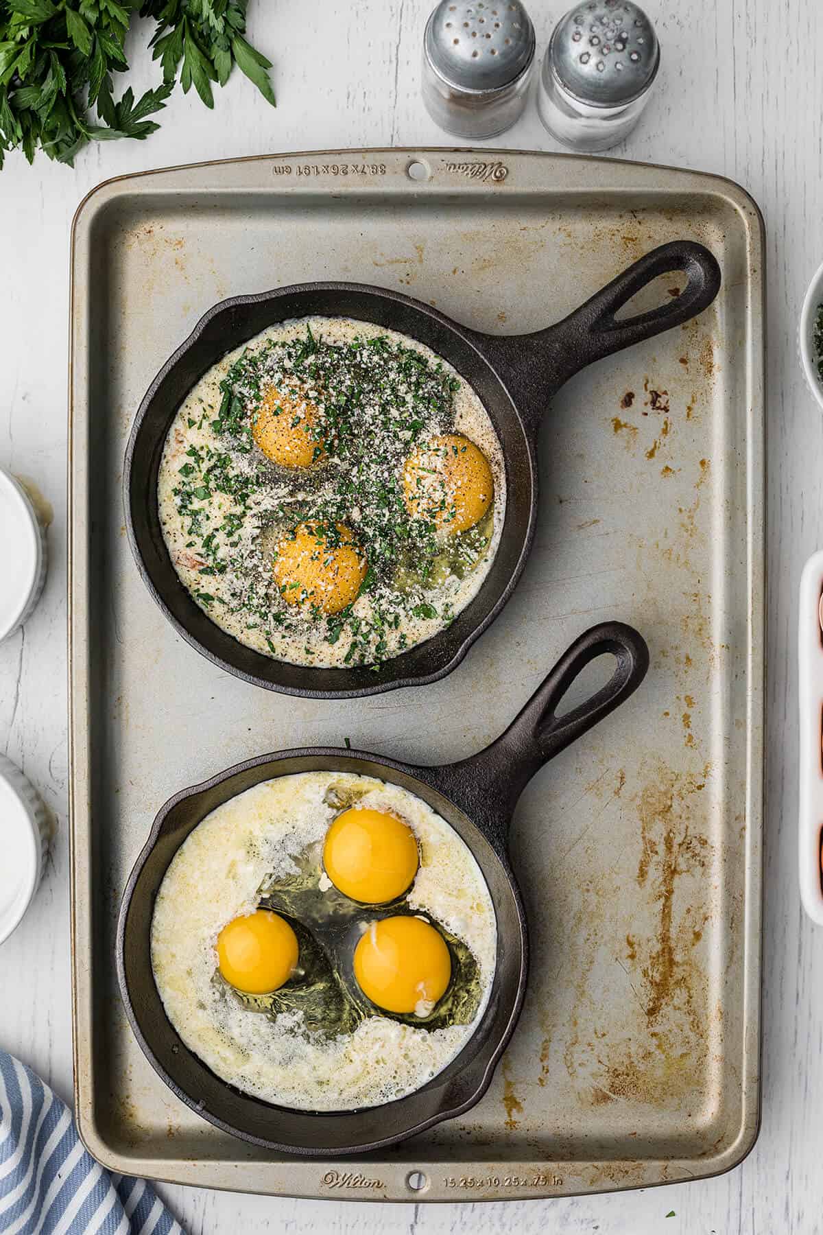 Eggs and herb mixture added to mini skillets.