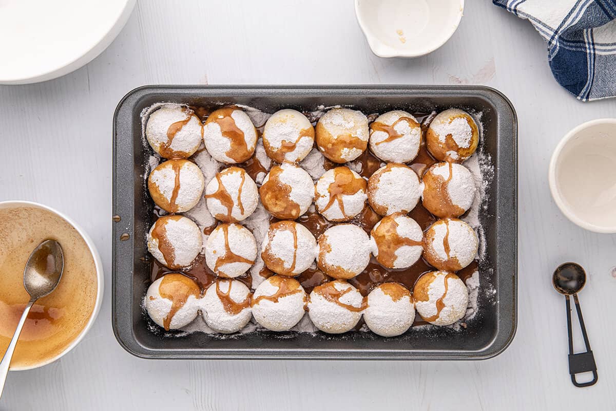 Melted butter and sugar mixture poured over rolls in baking pan.