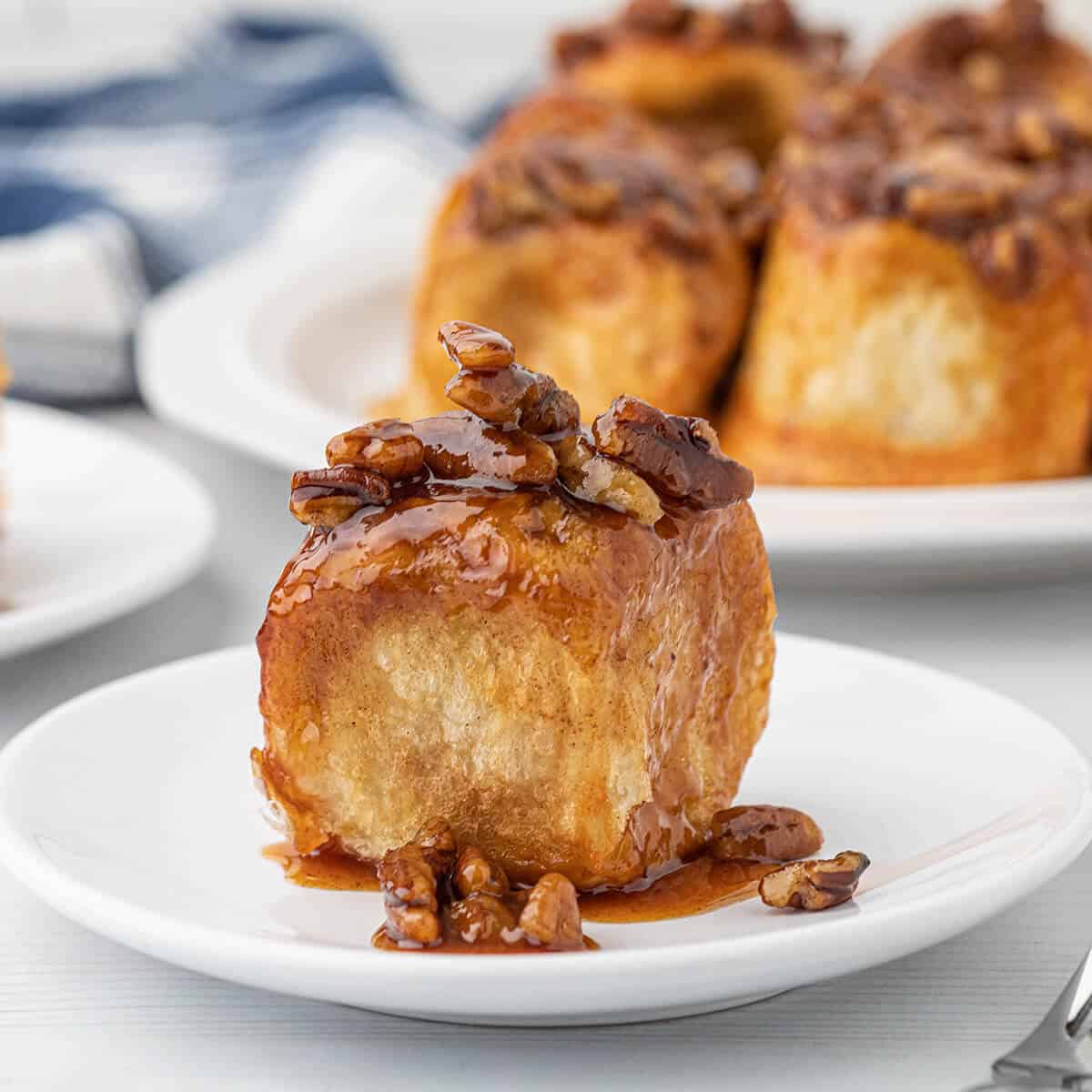 Finished overnight pecan sticky rolls on a white serving plate.