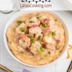 A serving a shrimp and grits in a white bowl.