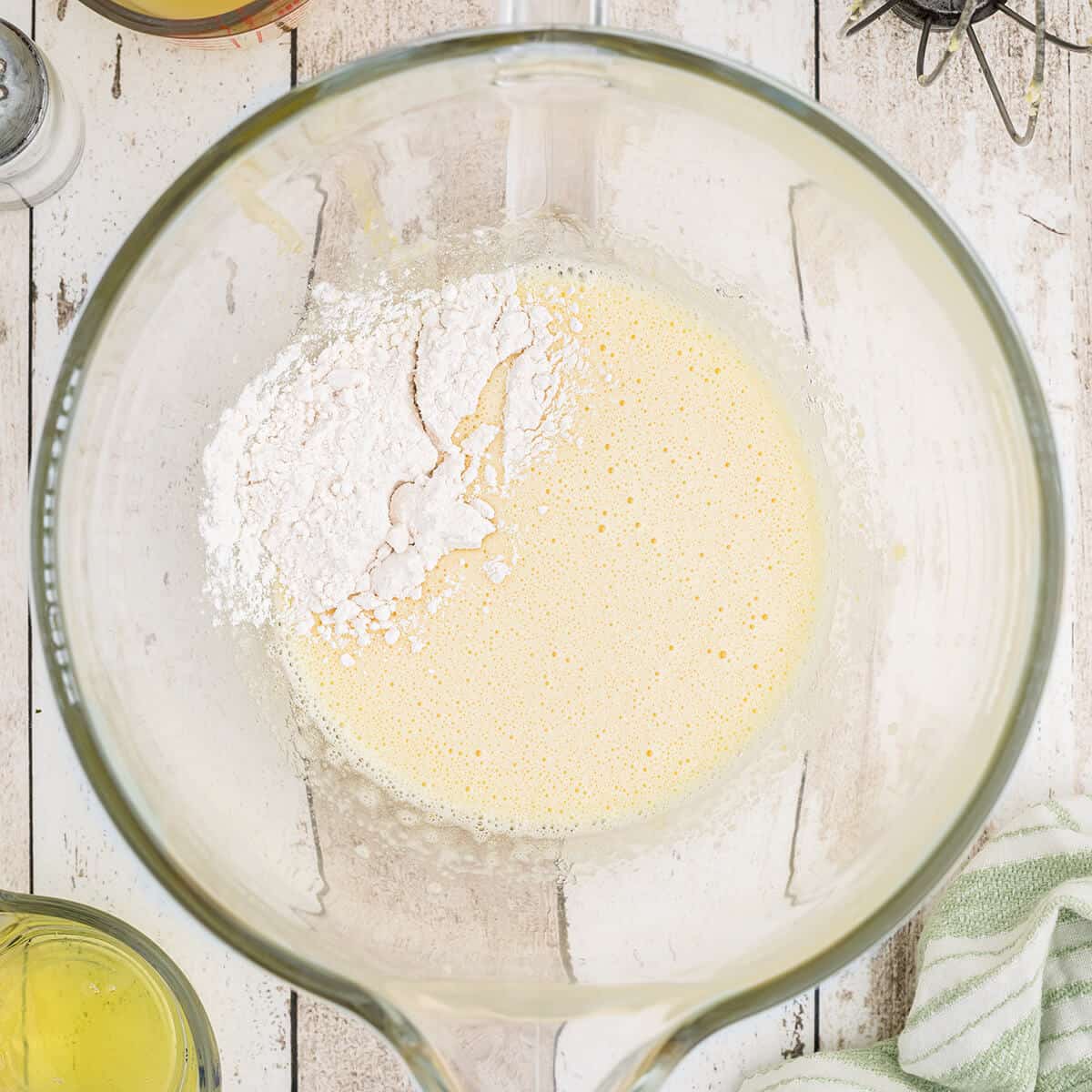 Add flour to cake batter in a glass bowl.