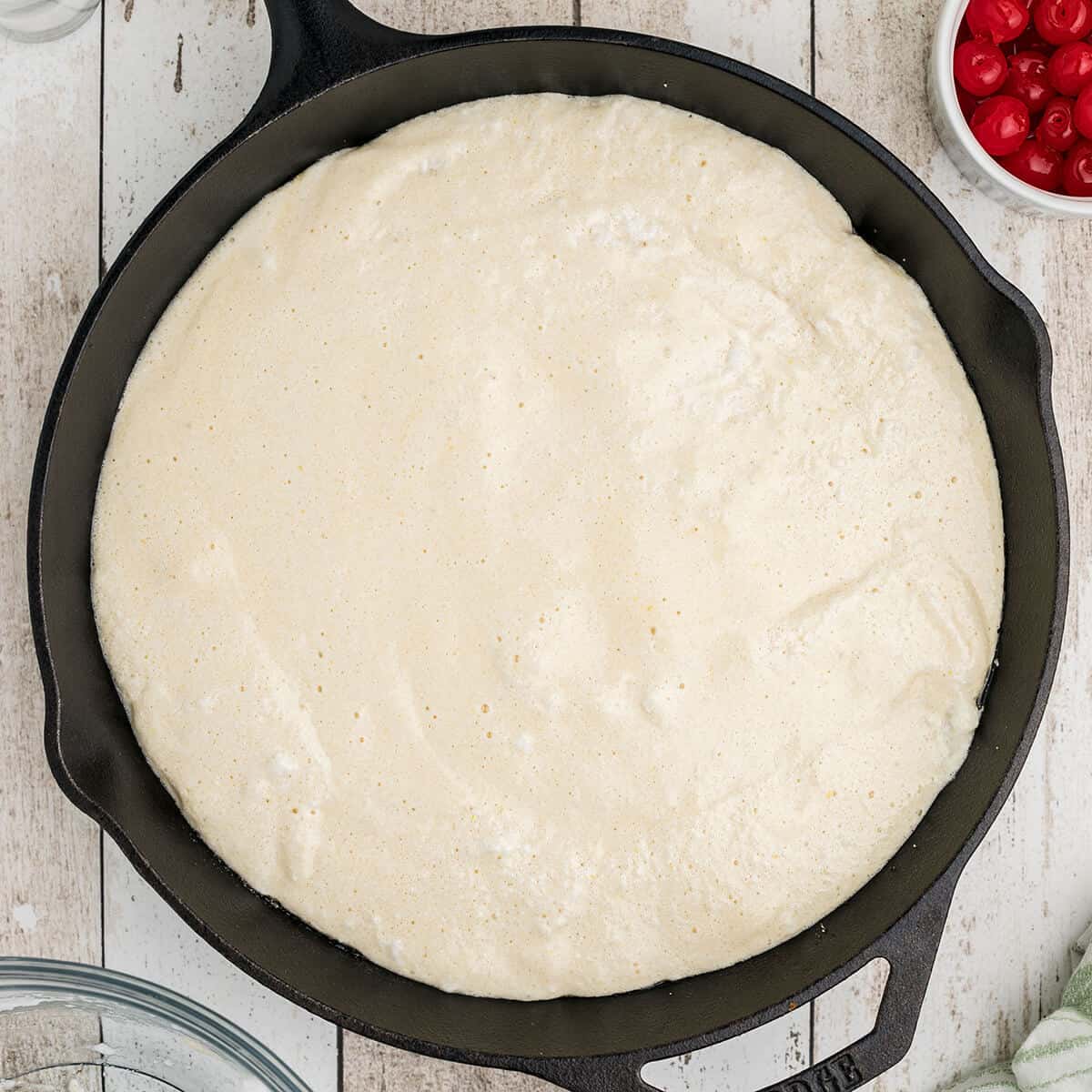 Cake batter completely added to cast iron skillet.