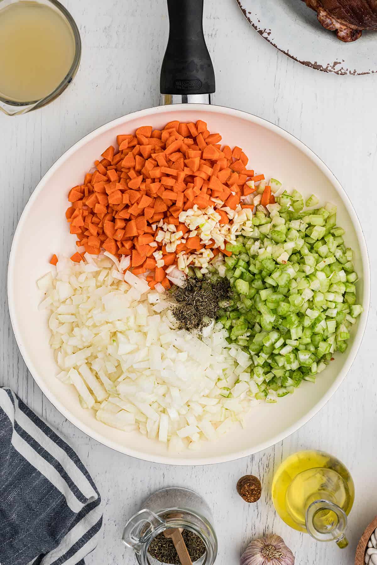 Diced vegetables and herbs in a skillet.