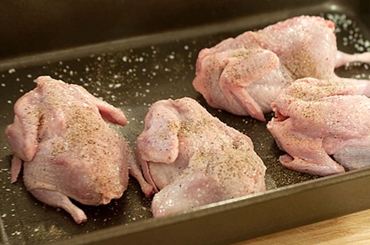 Quail in a pan coated with salt and pepper.