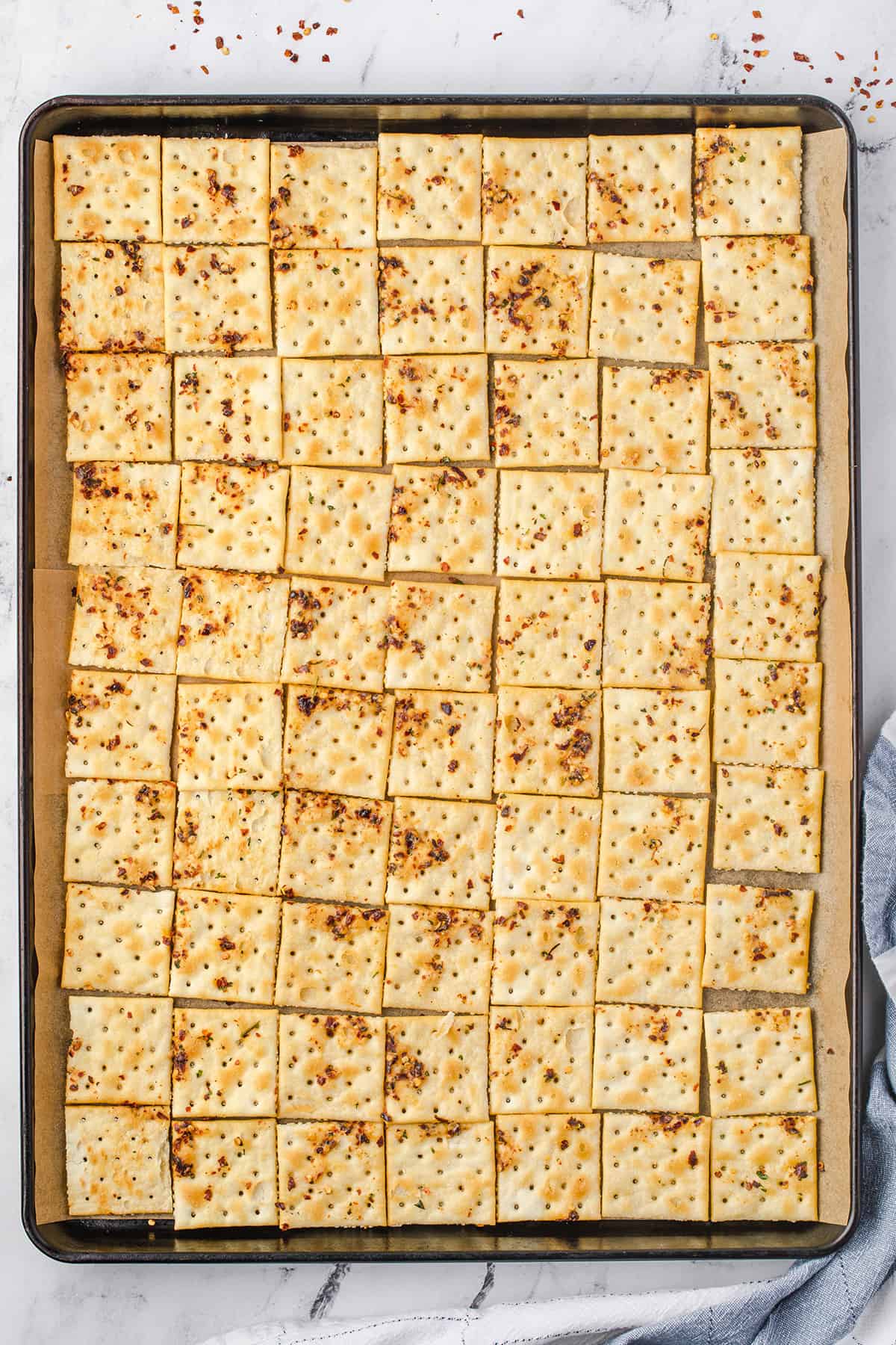 Crackers laid out on a baking sheet.