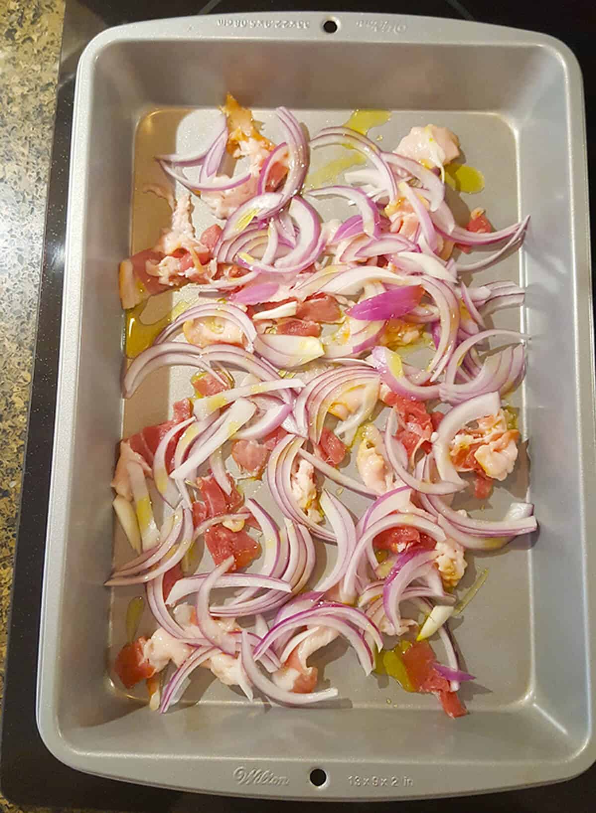 Bacon, onion, and olive oil in a baking pan.
