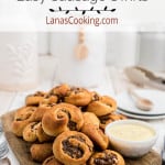 Finished sausage swirls on a board with dipping sauce.