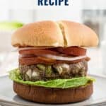 A meatloaf burger with lettuce, tomato, and onion on a bun, served on a plate.
