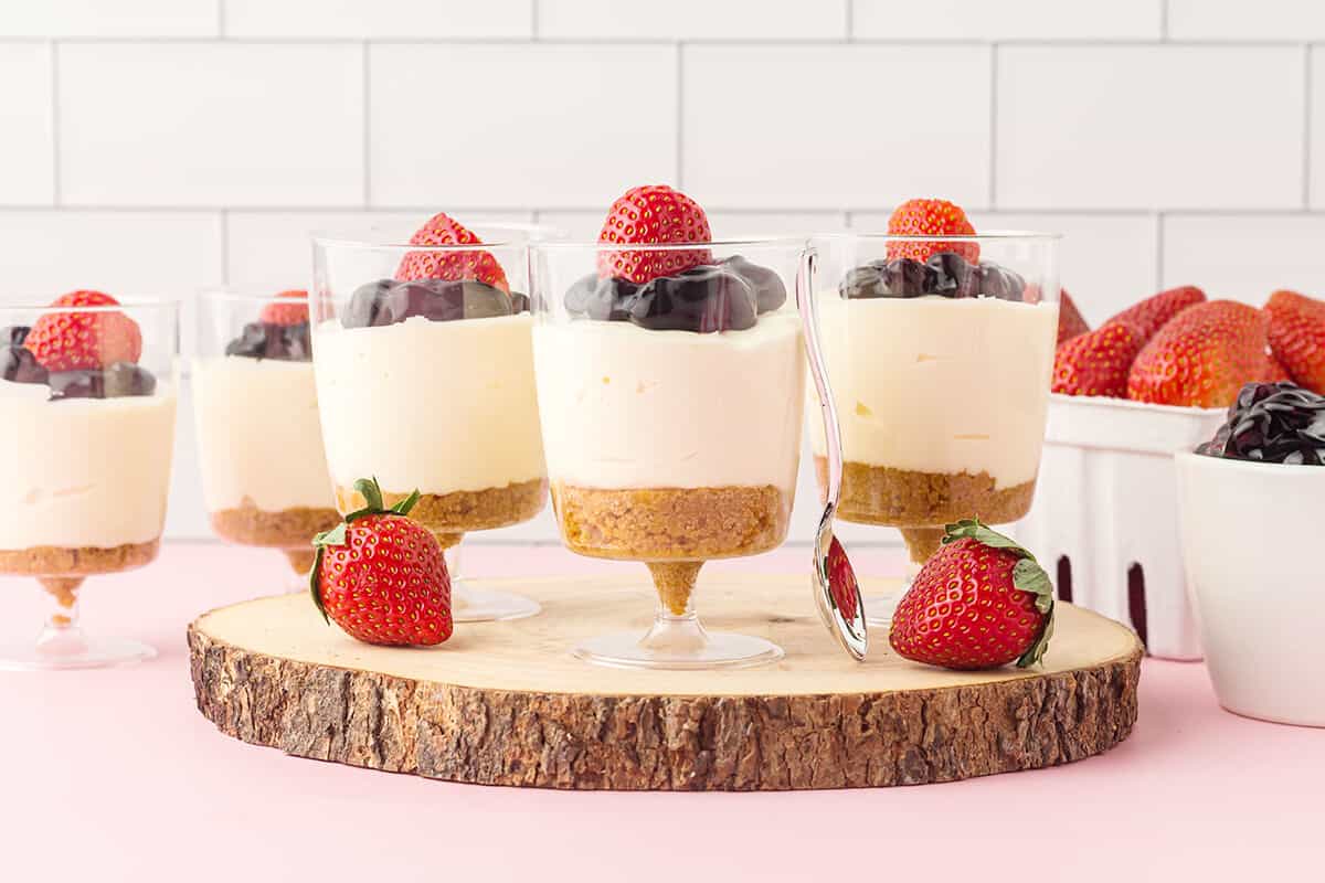 Finished individual no bake cheesecake cups topped with strawberries.