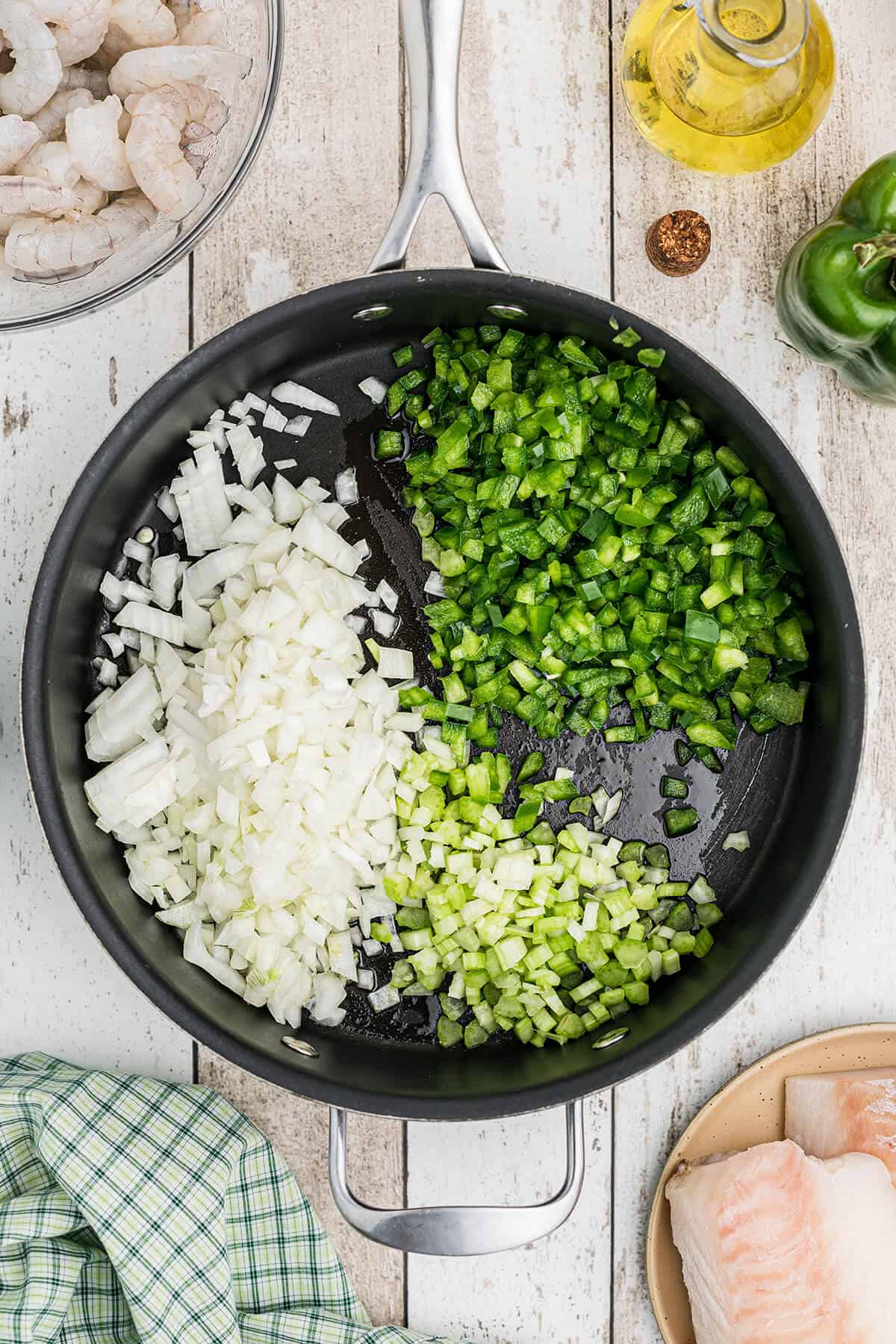 Onion, celery, and bell pepper added to oil in skillet.