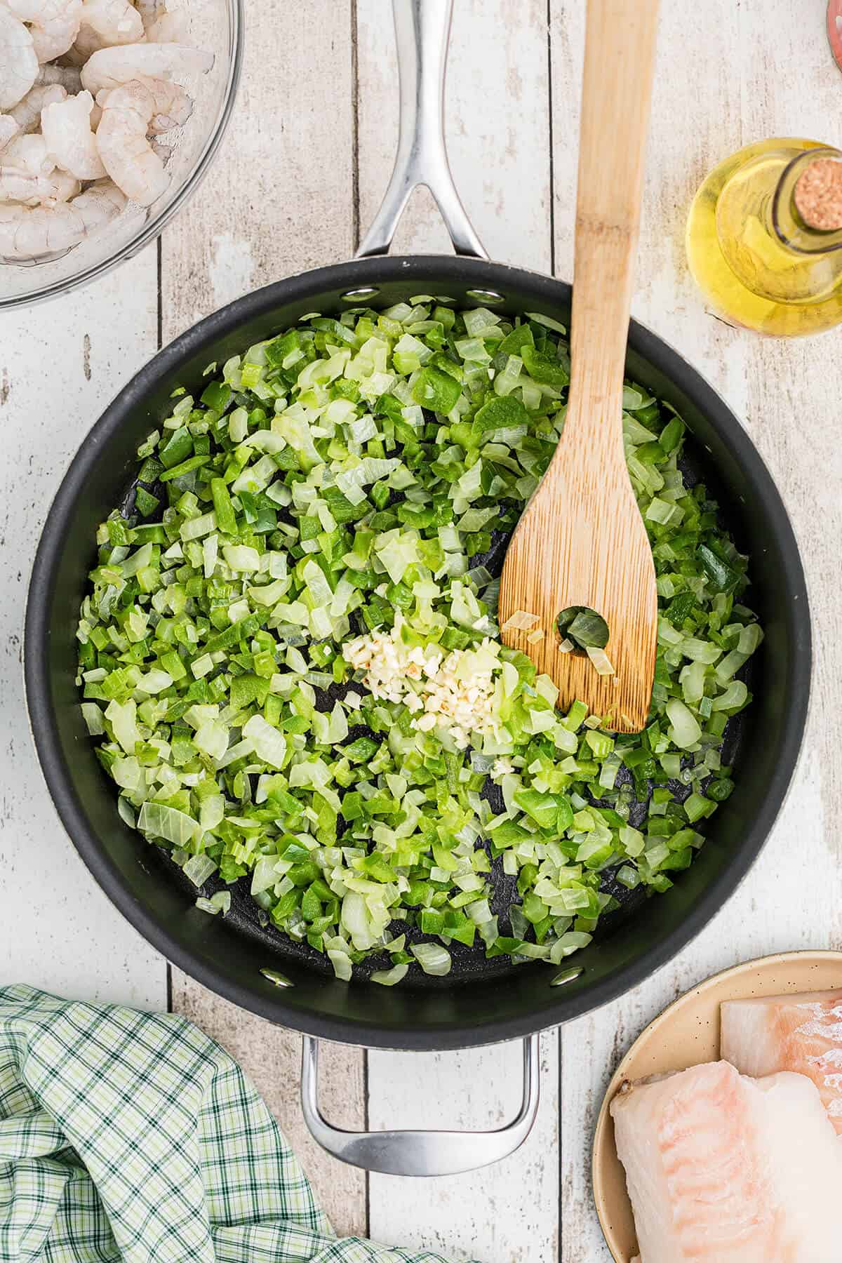 Garlic added to vegetables in a skillet.