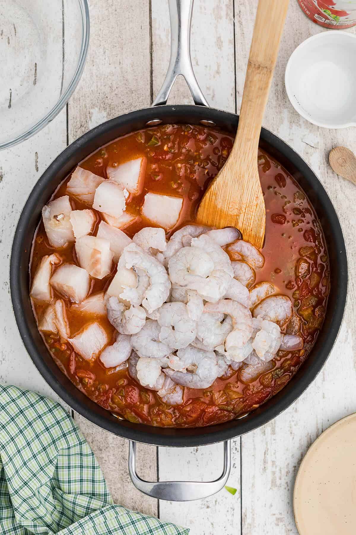 Shrimp and fish added to mixture in skillet.