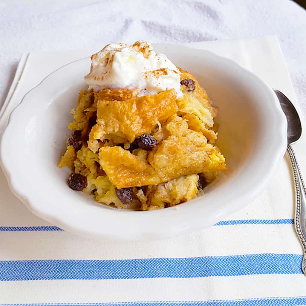 A serving of bread pudding in a white bowl.