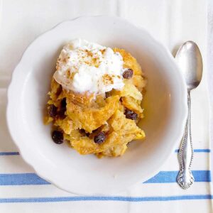 A serving of bread pudding in a white bowl.