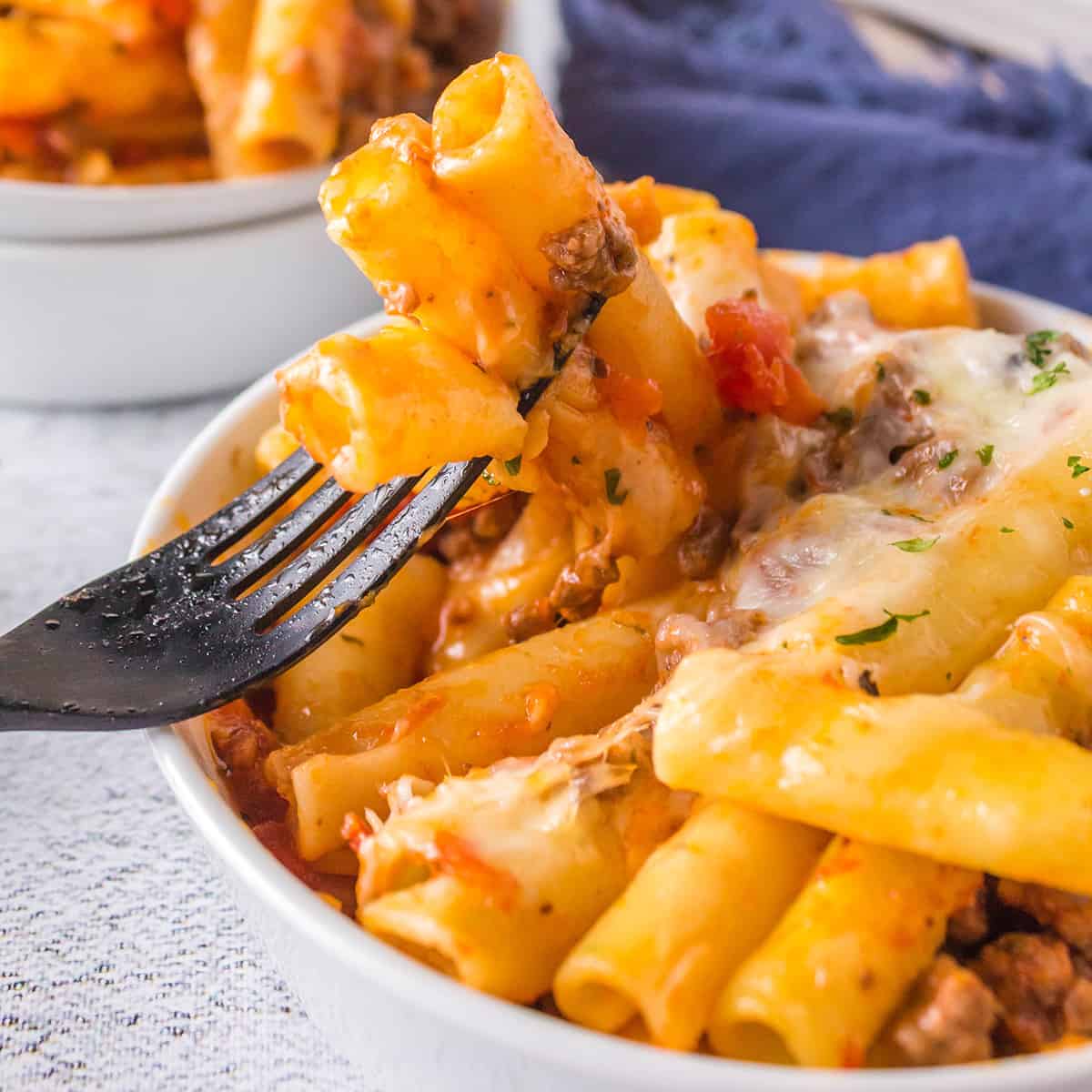 A serving of baked ziti in a white dish.