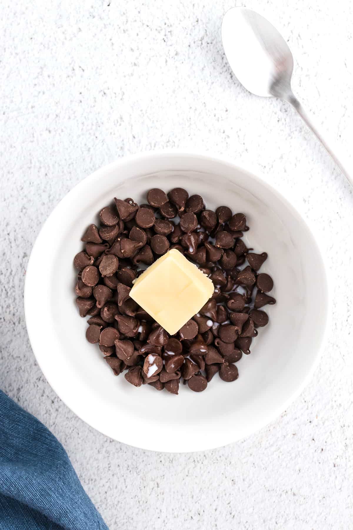 Chocolate chips, butter, and milk in a mixing bowl.