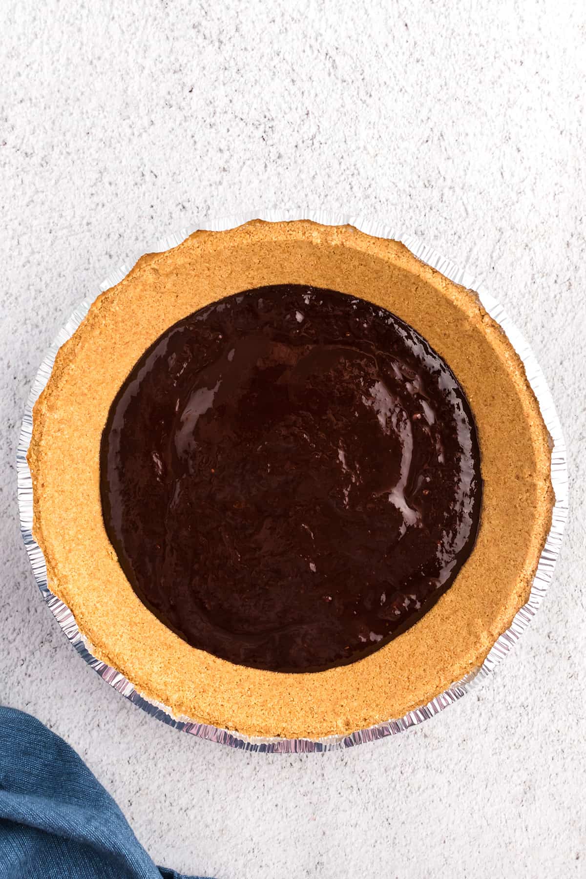 Melted chocolate spread onto bottom of a pie crust.