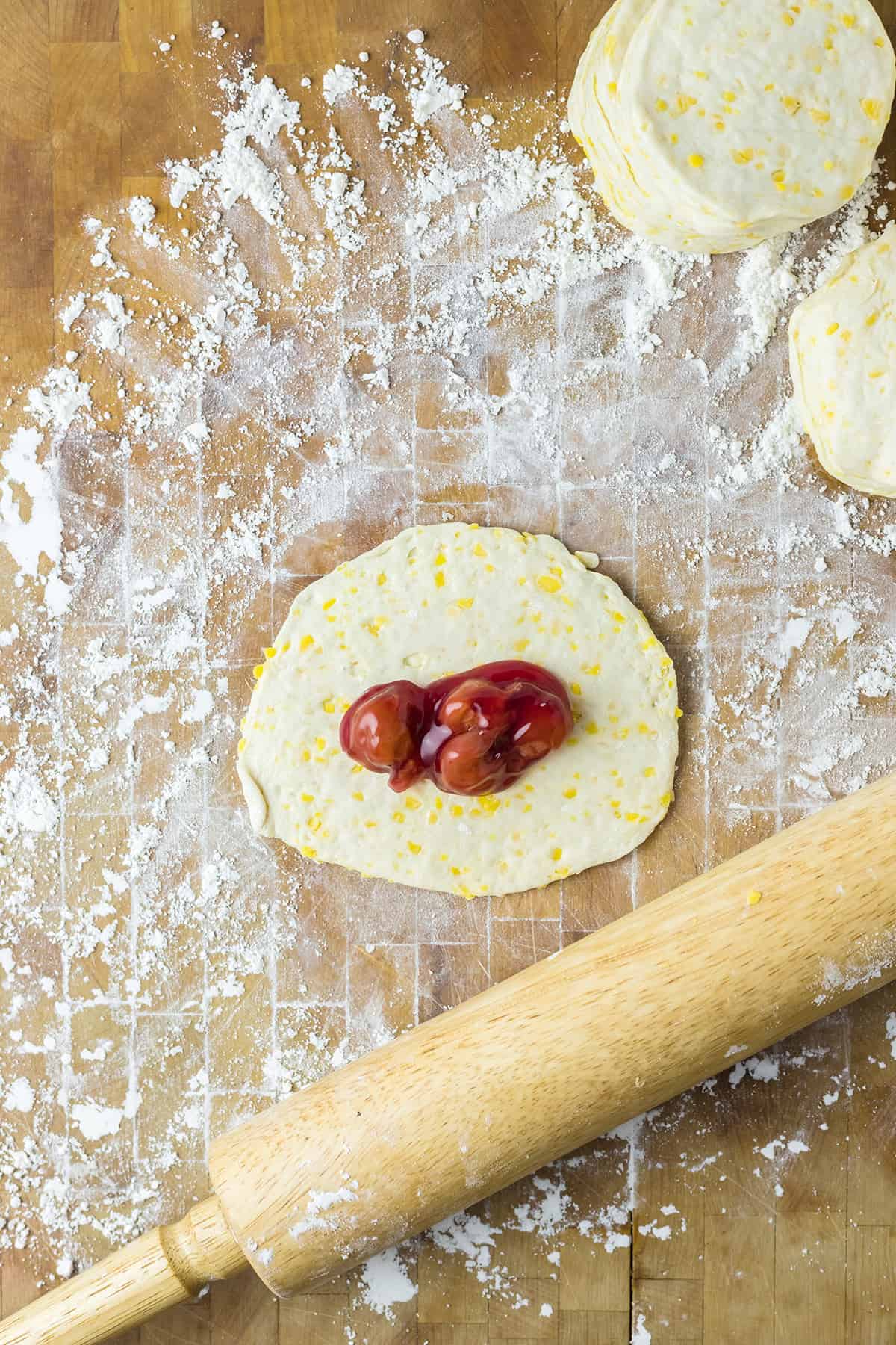 Cherry pie filling added on top of biscuit dough.