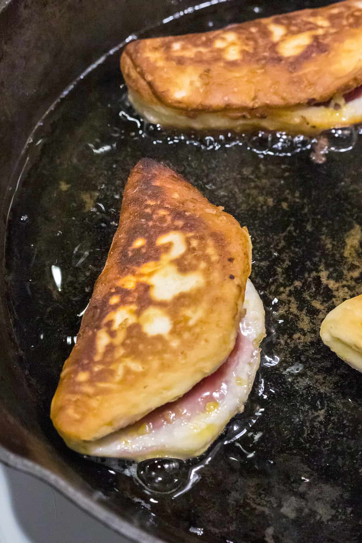 Hand pies flipped to fry on the second side.