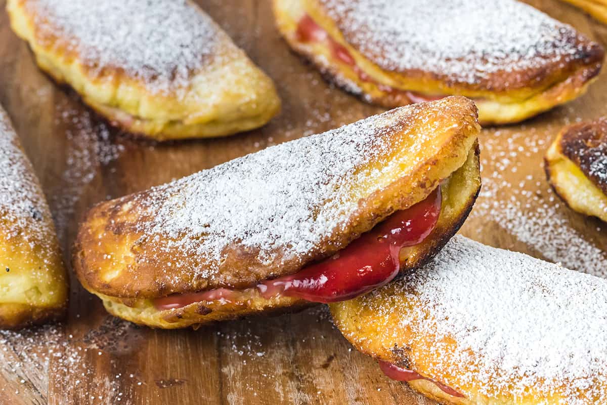 Finished fried hand pies on a wooden board.