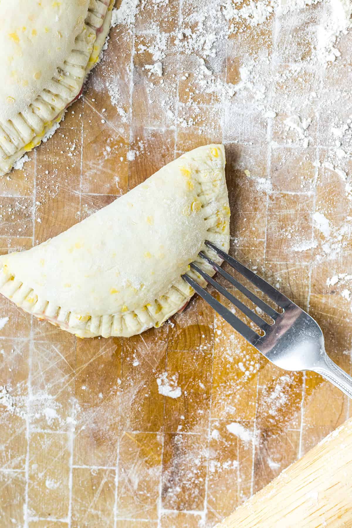 Sealing edges of the hand pie with a fork.