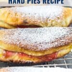 Three golden fried cherry hand pies dusted with powdered sugar on a cooling rack, with recipe text above.
