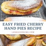Golden fried cherry hand pies dusted with powdered sugar, displayed on a cooling rack and a plate.