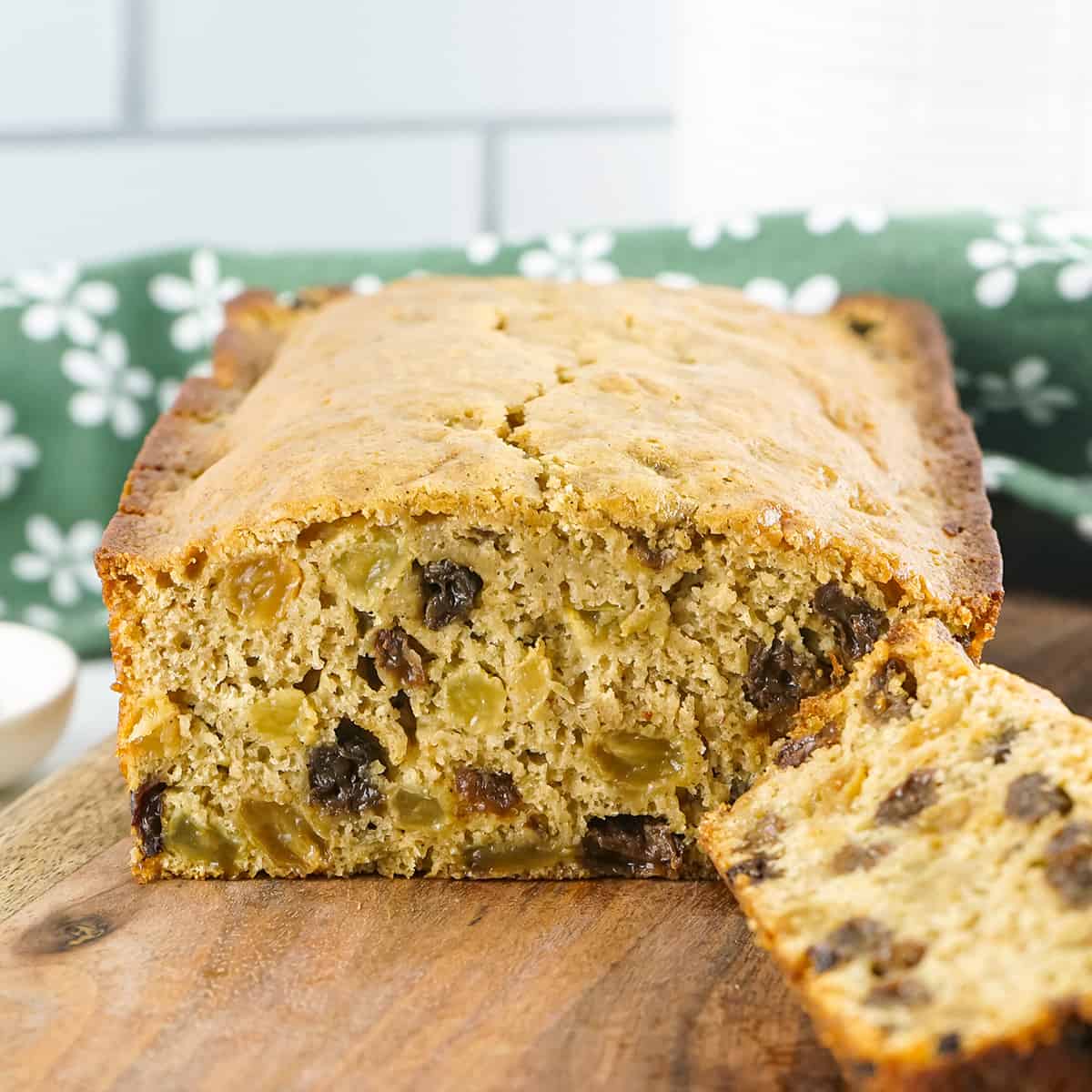 A loaf of Irish barmbrack on a wooden cutting board.