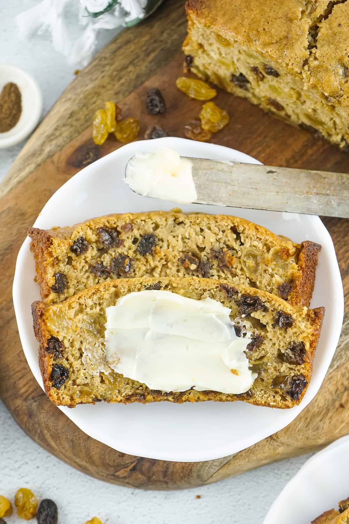 A slice of Irish barmbrack with butter spread on top.