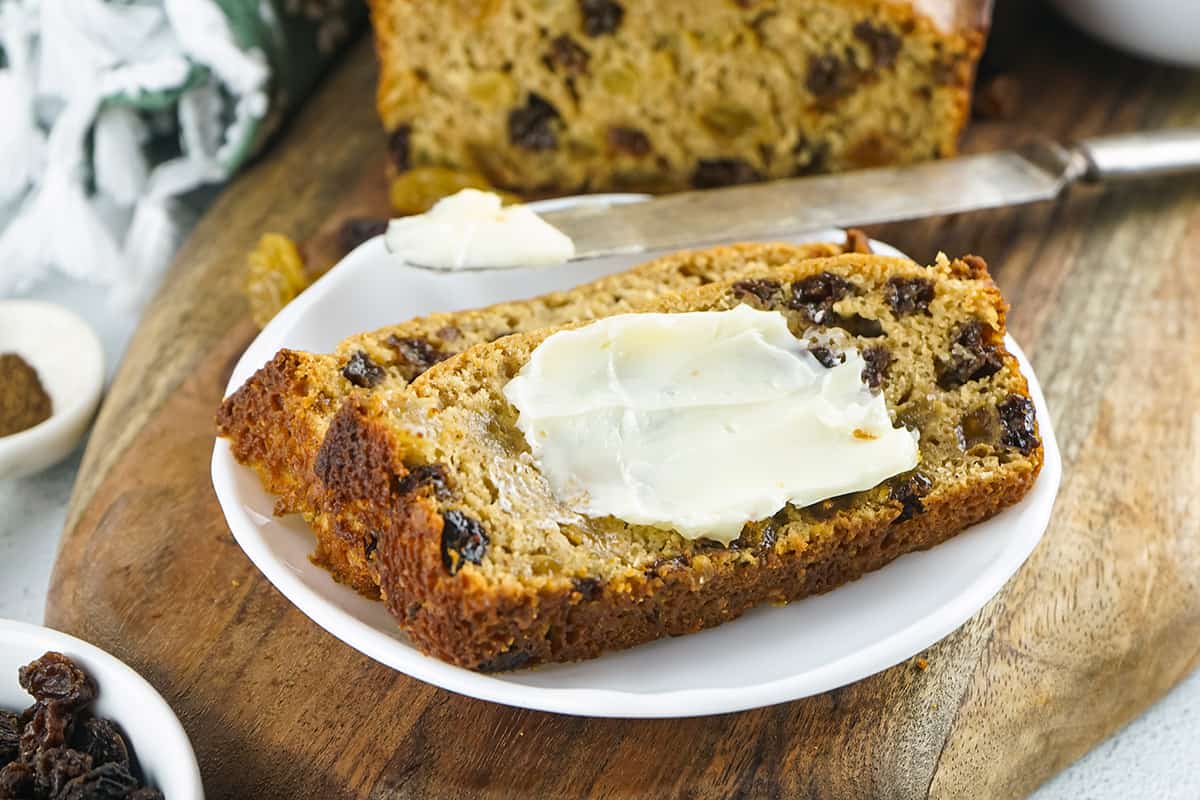 A slice of Irish barmbrack with butter spread on top.