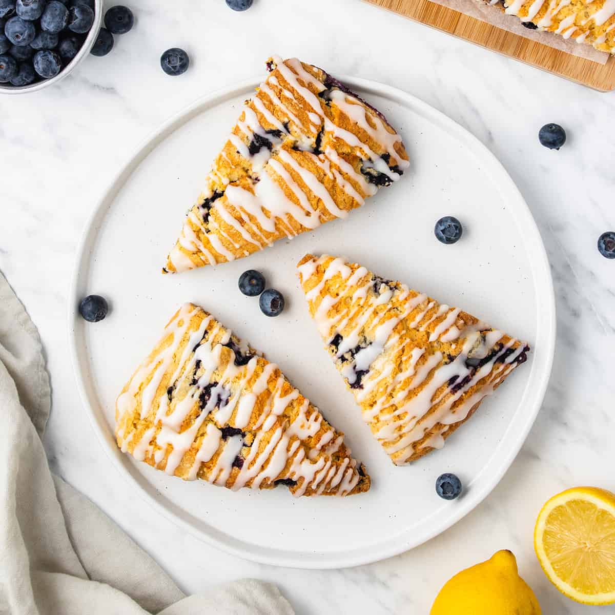 Lemon blueberry scones on a white serving plate.