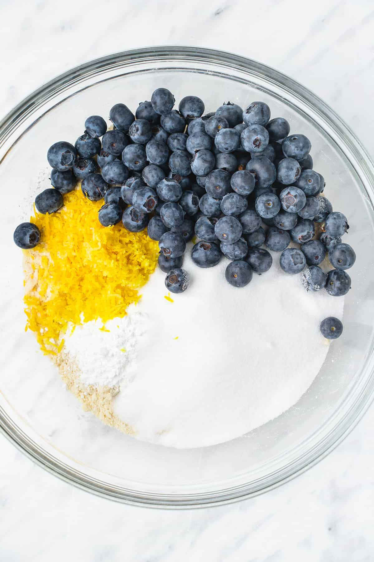 Blueberries, lemon zest, salt, sugar, and baking powder added to flour-butter mixture.
