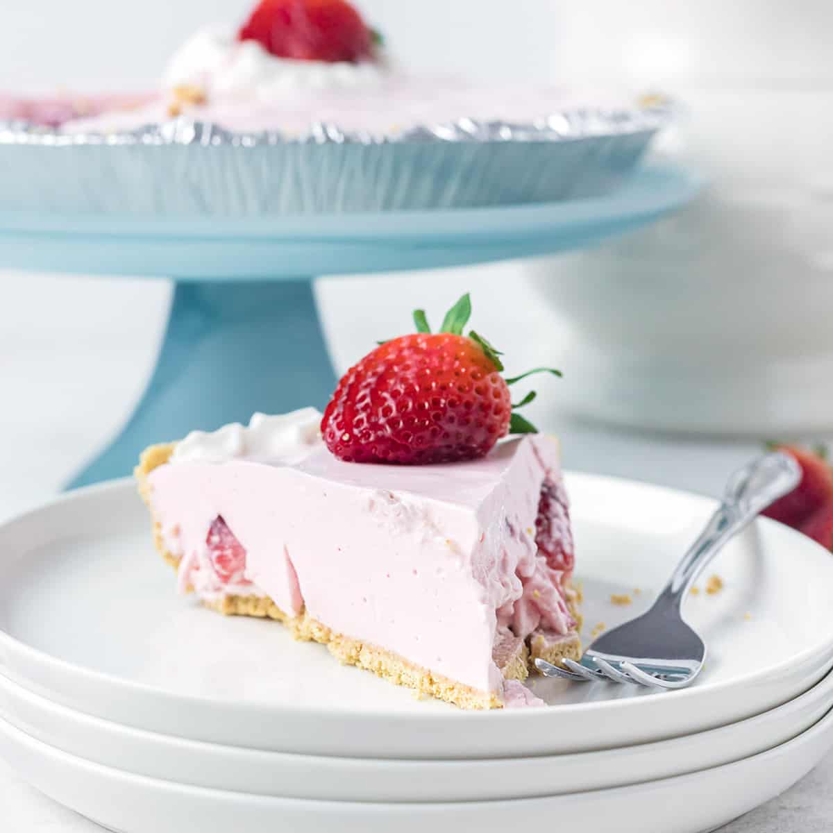 A slice of strawberry jello pie on a white serving plate.