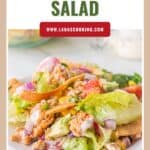 A plate of turkey taco salad with lettuce, tomatoes, red onion, corn, and creamy dressing.