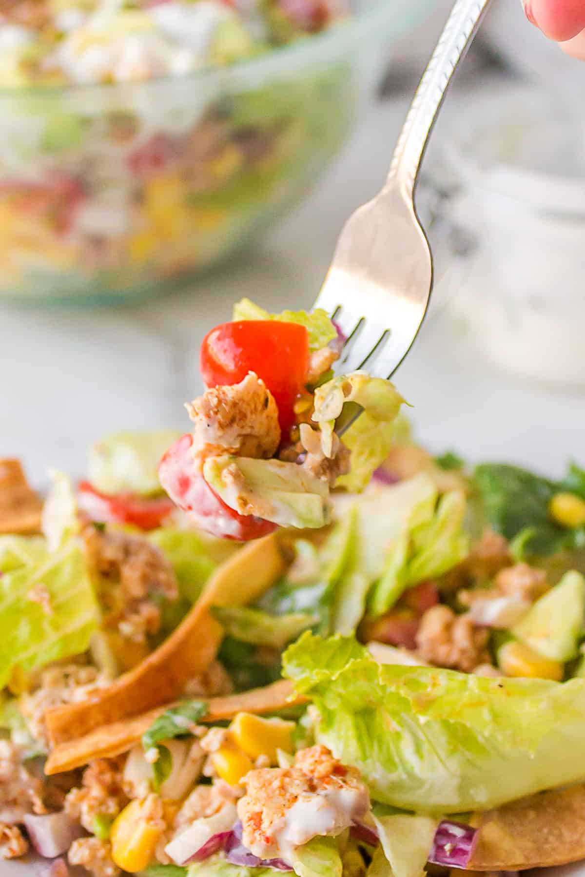 A bite of salad on a fork.
