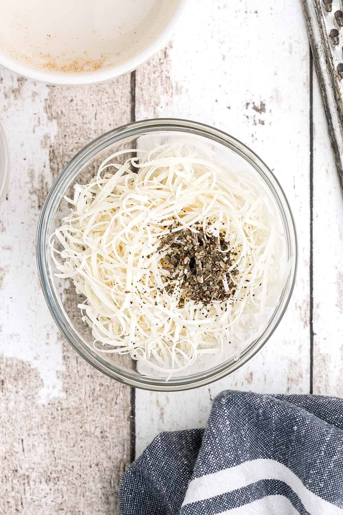 Parmesan cheese and dried basil in a bowl.