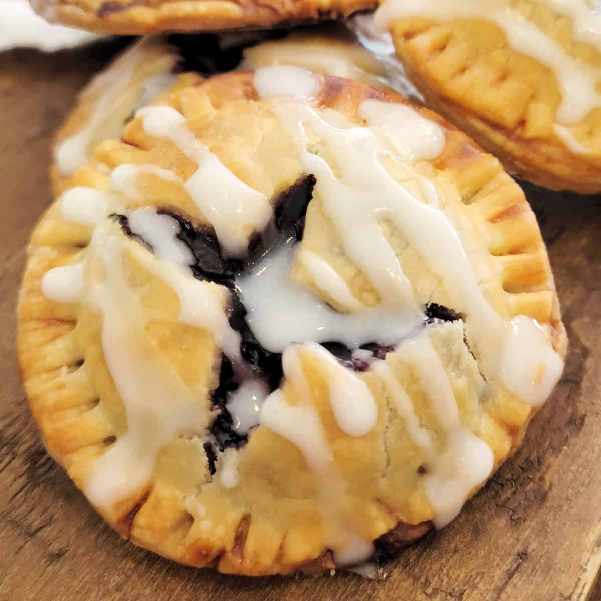 Finished blueberry pie cookies on a wooden board.