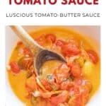 Wooden spoon stirring chunky cherry tomato sauce in a white bowl with orange liquid and tomato skins.