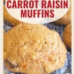 Close-up of a carrot raisin muffin in a blue liner with text Low Fat Carrot Raisin Muffins above it.