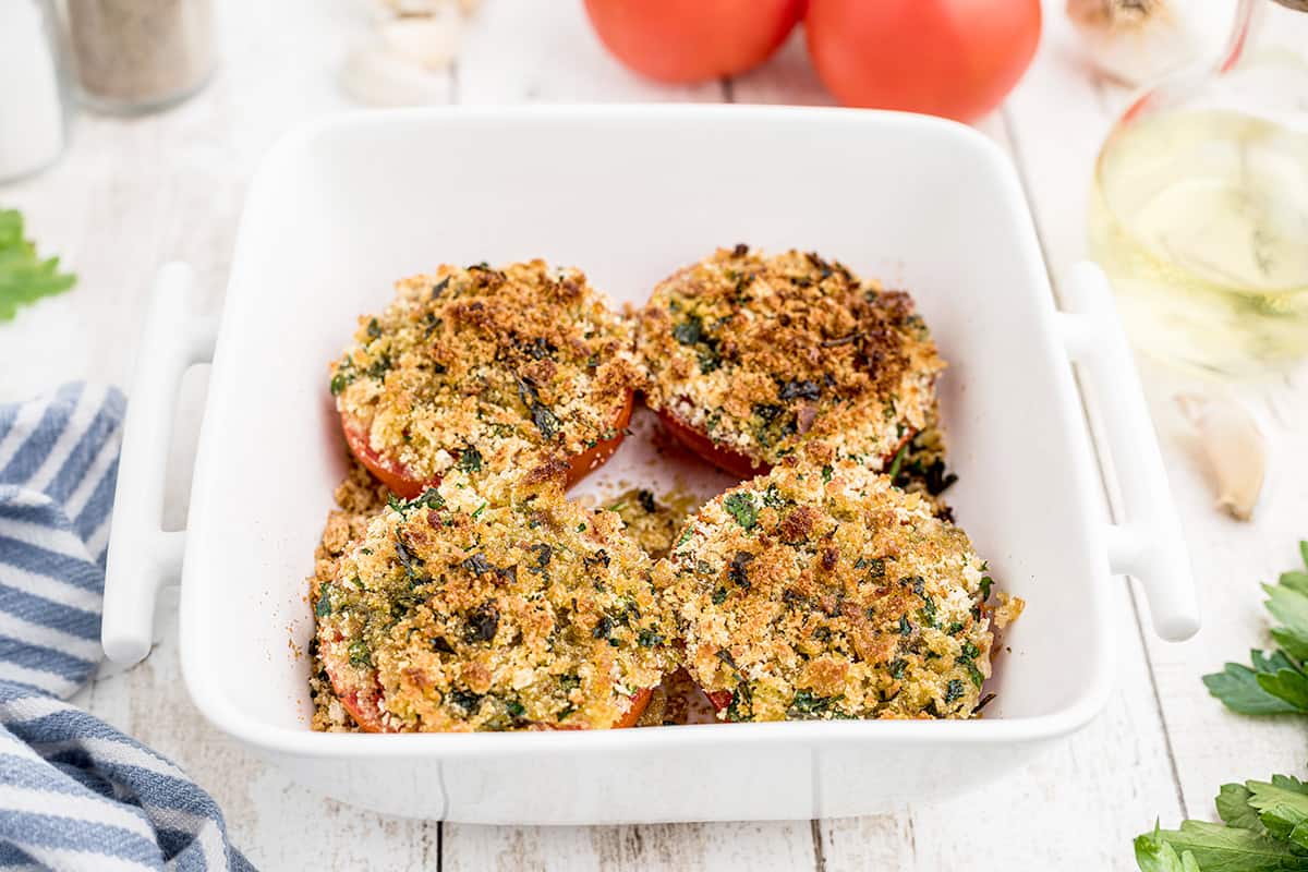 Finished tomatoes in a white baking dish.