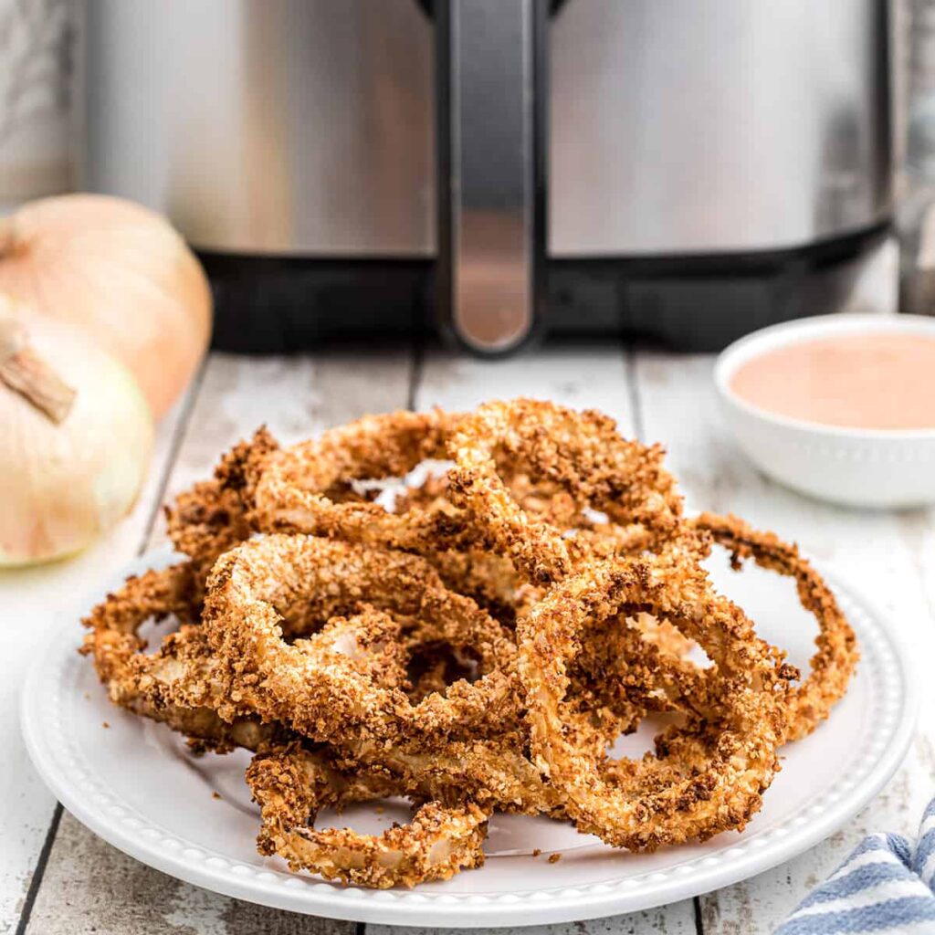 Finished onion rings on a white serving plate.