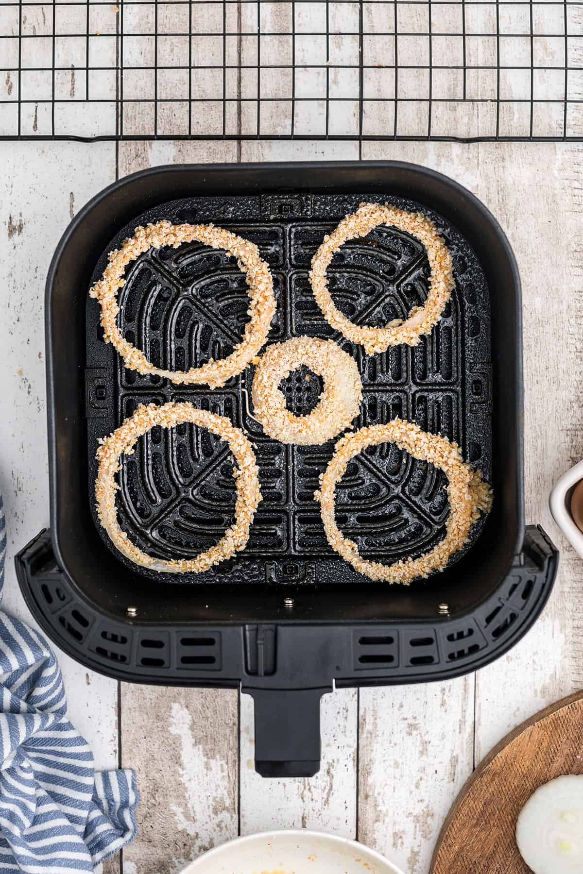 Prepared onion rings in the air fryer basket.